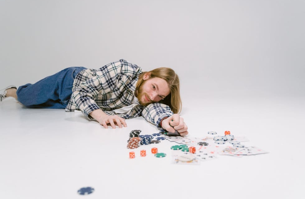 A person lying on the floor with gambling chips scattered around them