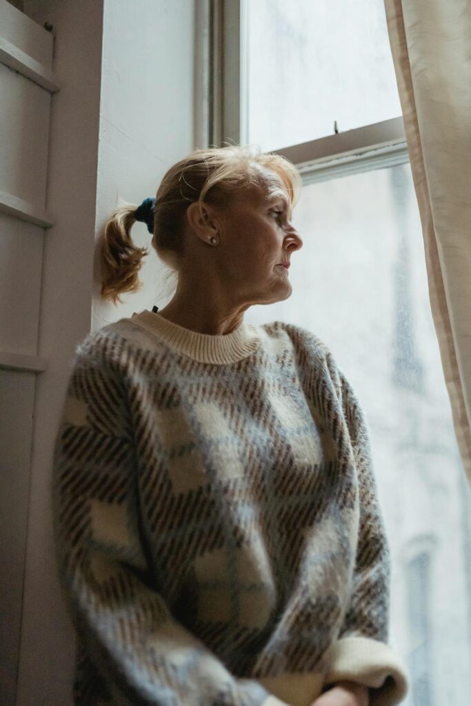 a women with a sad expression looking at the window and thinking if she should go to a borderline personality disorder treatment facility​​