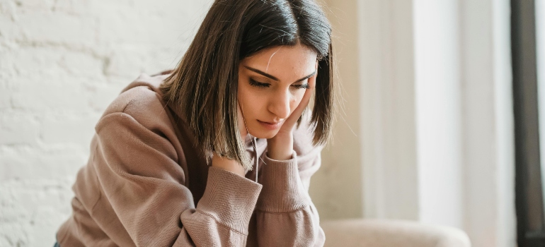 Sad young woman sitting on a couch