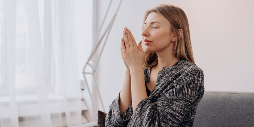 woman doing breathing exercises to get rid of shortness of breath from anxiety 