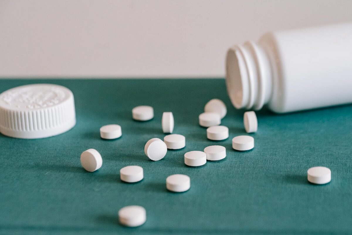 White pills spilled out of a white jar