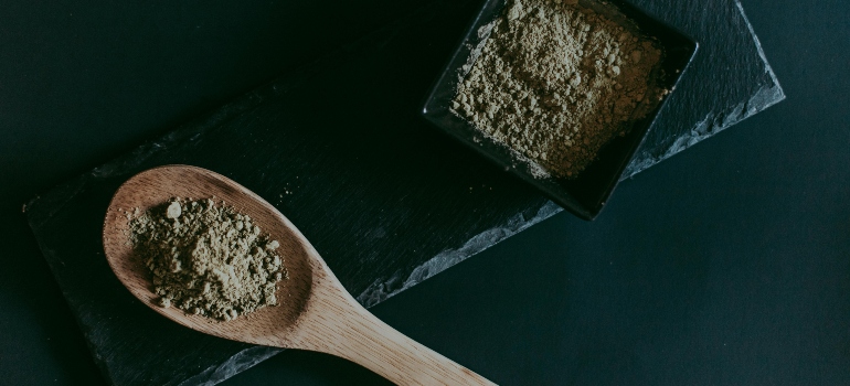 Close-up of crushed kratom leaves on a neutral background.