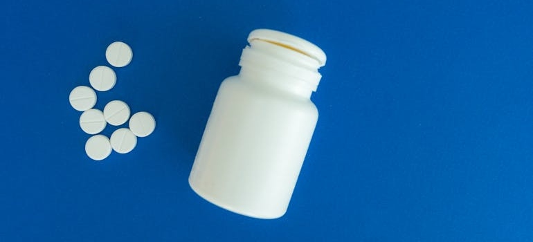 Antidepressants next to a white jar on a blue surface