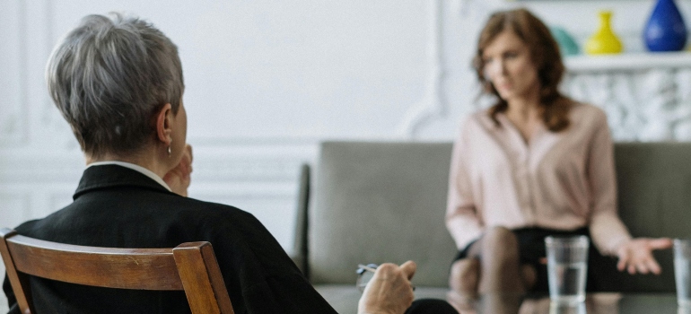 Therapist and client in a calm therapy room, talking about types of trauma and how to heal.