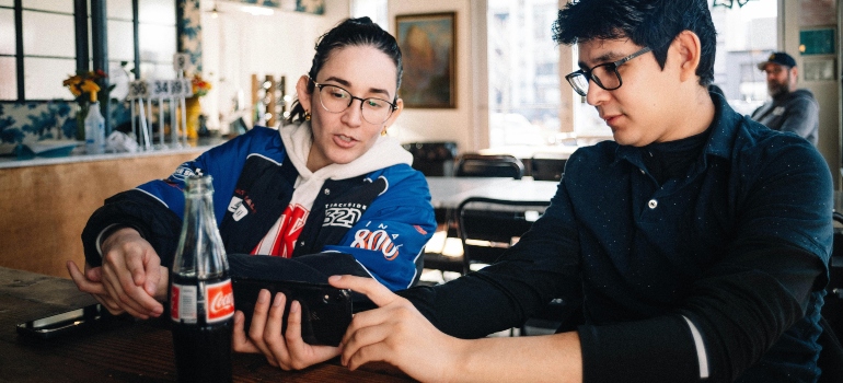 Friends placing bets together on a phone, reflecting problem gambling in Massachusetts.