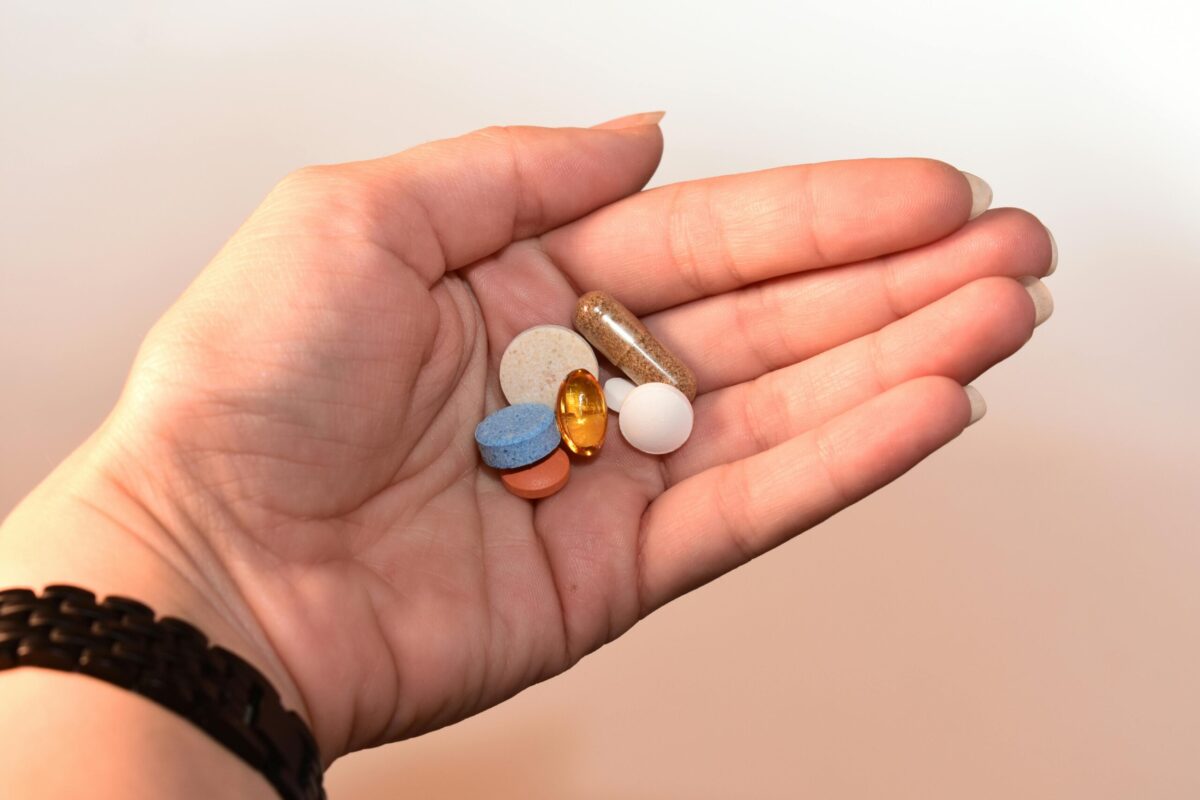 Person Holding Medication Pill and Capsules.