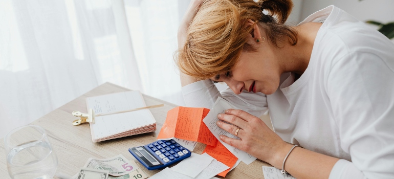 A stressed individual reviewing bills.