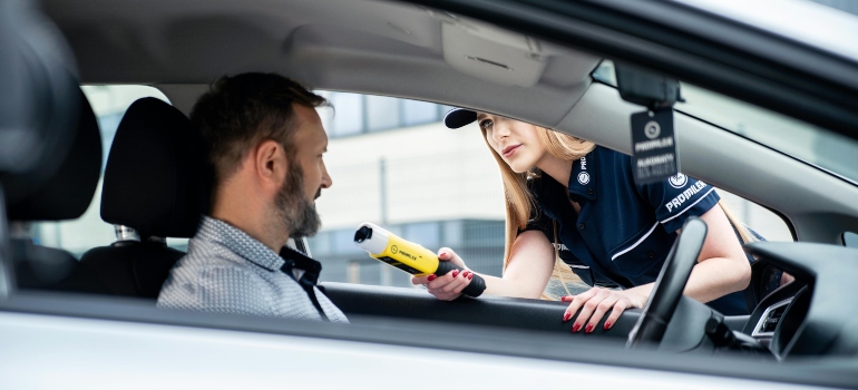 Close-up of a police officer performing a breathalyzer test.
