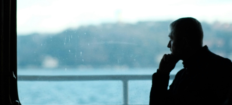 Person sitting quietly, looking through the window.